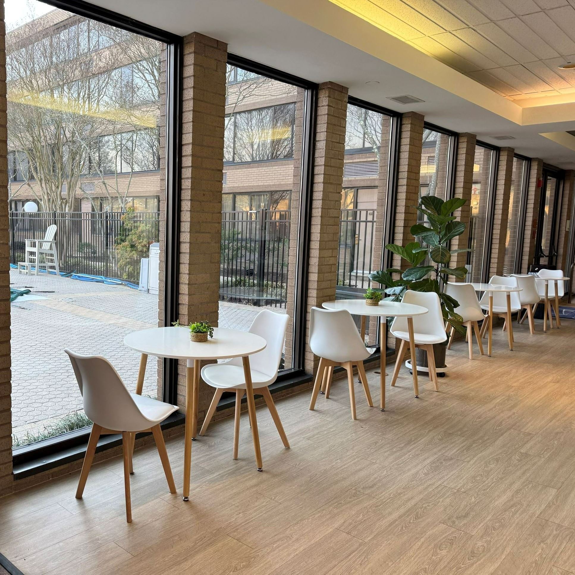hallway with windows including a brochure rack, tables and chairs