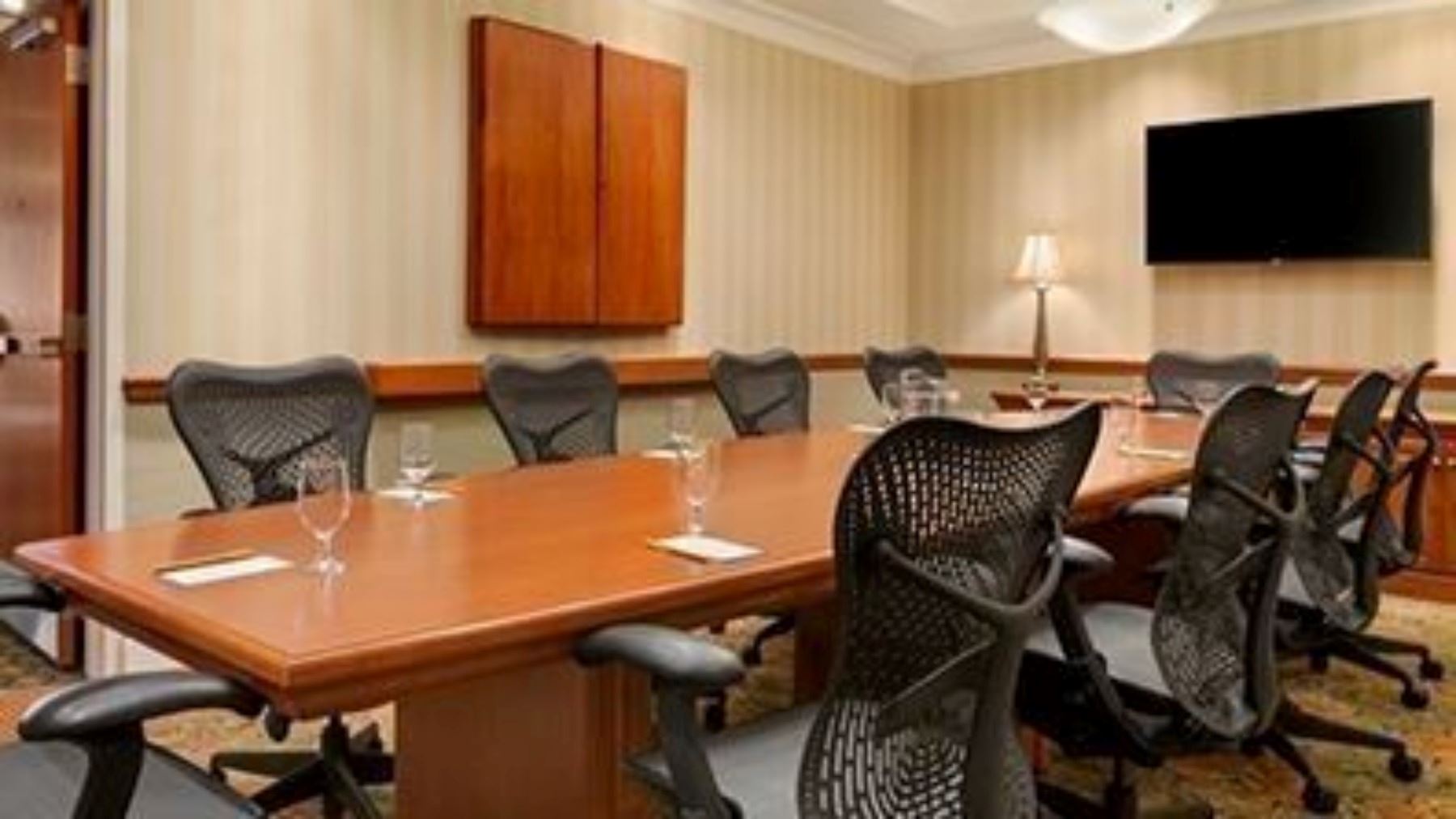 Hilton meeting rooms with chairs, a large table and a TV