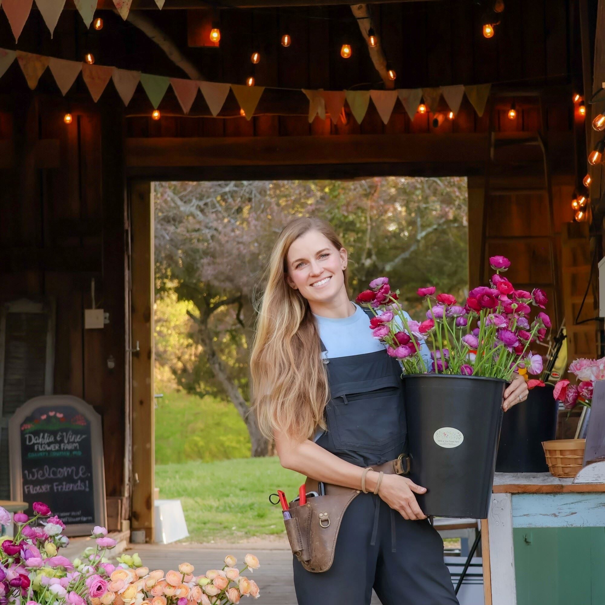 Woman holding bucket of pink flowers